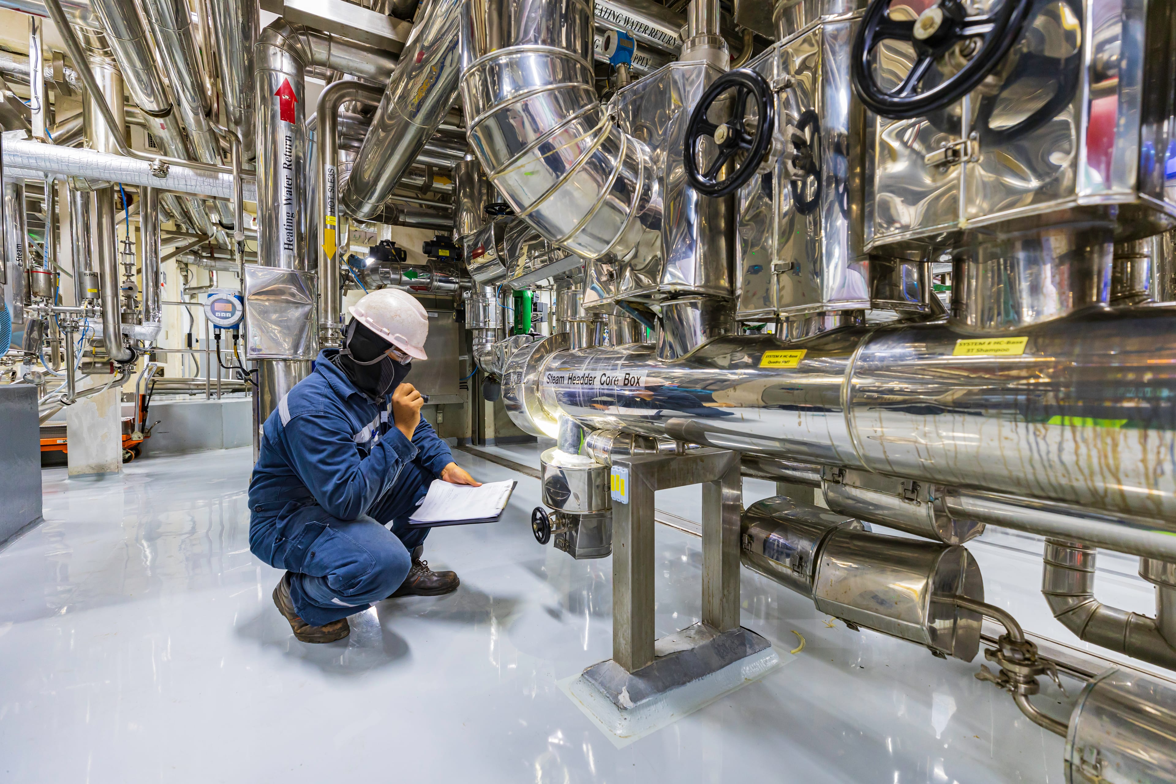 Worker inspecting industrial process equipment