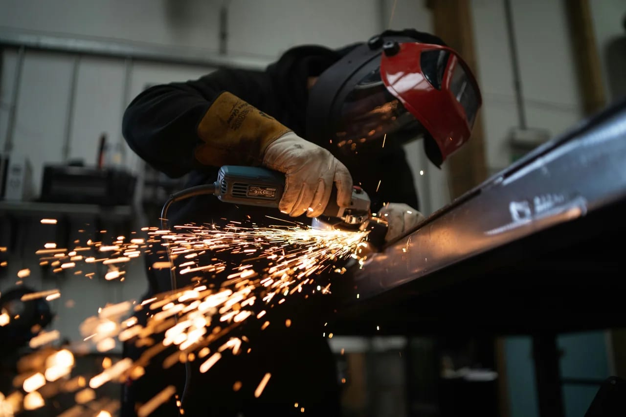 Worker grinding metal in a fabrication shop